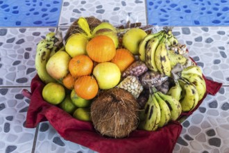 Colorful fresh fruits mixed in the basket lay on the tiling