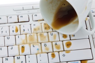 Cup of coffee spilled on a computer keyboard. Damage for insurance, Cup of coffee spilled on a