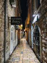 Budva, Montenegro - 25 december 2022: Signboard on a narrow street with stone houses. Caption: Old