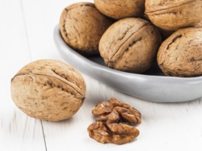 Inshell walnut on white wooden background