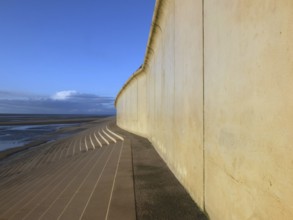 Perspective view of the concrete seawall in blackpool with steps leading down to the beach in warm