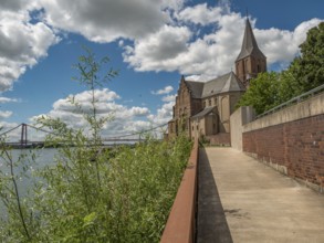 Walkway along a church, in the background a bridge and clouds in the blue sky, emmerich, lower