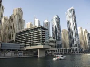 Modern skyscrapers on the riverbank with a boat on the water, impressive skyline of a modern city