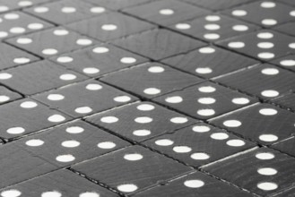 Composition of lying black domino bricks with white dots
