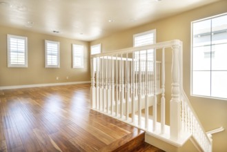 Large empty room with wood floor, molding and windows and stairs. Modern bright room, interiors