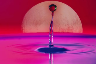 A drop of water rises into the air in front of a large full moon and in a pink-red sky, Planet