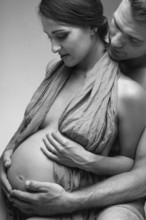 Young man and pregnant woman in studio in lingerie