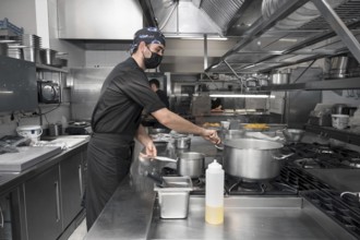 Chef cooking in modern industrial kitchen. High quality photo