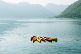 Kayaks moored in the water. Empty kayaks without people. In the Bay of Kotor, in Montenegro