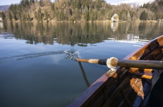 Young woman using paddle on a wooden boat, Lake Bled Slovenia rowing on wooden boats on a sunny day