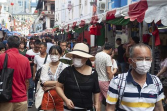 24.01.2020, Singapore, Republic of Singapore, Asia, Pedestrians wearing face masks stroll through a