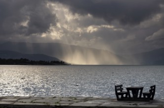 Empty picnic table in in the Norwegian village Herand in front of a dramatic sky over the