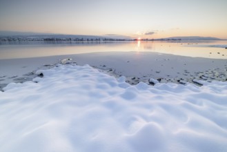 Winter landscape with a frozen lake at sunset, soft snow cover and reflecting water, Seegarten,