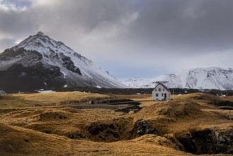 Lonely house on the basalt coast and Stapafell mountain near the snfellsjoekull glacier,