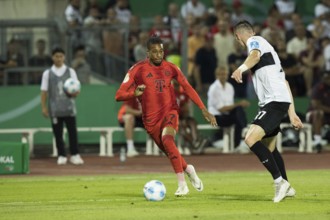 Football match, Michael Akpovie OLISE FC Bayern Munich left on the ball in a duel with Niklas KOLBE