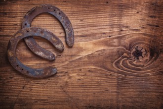 Two horseshoe on vintage wooden board close up happy concept