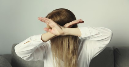 Close-up upset young woman shows stop, no or enough sign with palm of hand, refusal gesture,
