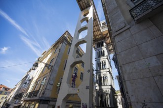 An urban area with historic buildings and an iconic lift under a blue sky in Lisbon, Elevador de