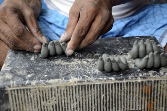 Man making fingers of clay, Kumartuli, Kolkata, West Bengal, India, Asia