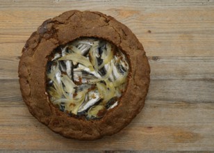 Traditional Finnish rye pie with vendace on a wooden table