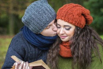 Loving couple reads a book in the autumn garden