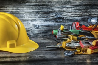 Construction helmet and set of tools on vintage wood