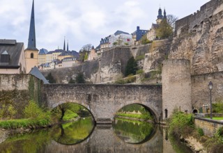 Stone bridge reflected in the water, and the ruins of a former famous castle, representing the