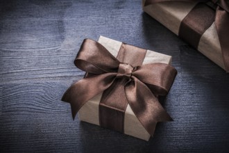Present boxes with tied ribbons on wood board holiday concept