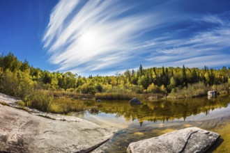 Indian summer in Manitoba, Canada. Incredible cirrus clouds over the Winnipeg River. Old Pinawa Dam
