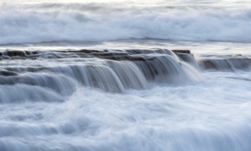 Rocky seashore with wavy ocean and waves crashing on the rocks at Akrotiri coast area in Limassol,