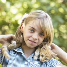 Girl play with kitten outdoor in the park