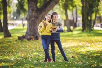 Friendship between siblings. Siblings together outside with bright coloured background. Kids autumn