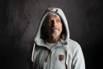 Elderly man with hoodie and hood on his head