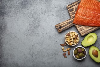 Food sources of healthy unsaturated fat and omega 3: fresh raw salmon fillet, avocado, olives, nuts