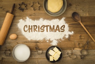 Collection of ingredients and utensils for baking Christmas biscuits with the word Christmas