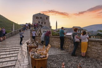 People on the old bridge watching sunset in Mostar, Bosnia and Herzegovina