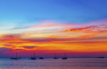 Yachts boats in front of the most beautiful colorful sunset at Tropical Paradise island Koh Phayam