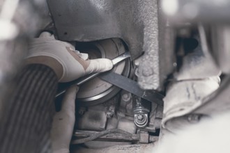 Hands of car mechanic in auto repair service