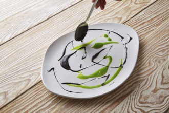 Modern cuisine chef preparation with creamy spots Molecular gastonomy