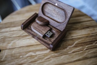 USB drive in a wooden box, resting on a wooden surface with a natural finish