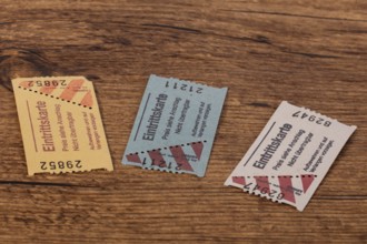 Drei Papiertickets auf einem Holztisch