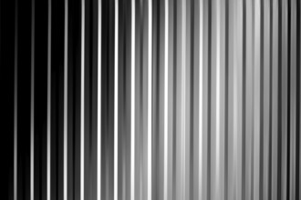 An abstract black, white and grey striped surface with shadows and vignettes