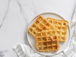 Perfect savory keto waffles. Two ingredients chaffles on plate over white marble background. Eggs