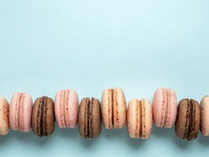 Macarons with copy space. Row of perfect french macarons or macaroons on blue background. Top view