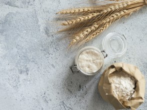Wheat sourdough starter. Top view of bread making ingredients - glass jar with sourdough starter,
