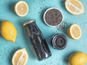 Detox activated charcoal black chia water or lemonade with lemon on bright blue background. Two