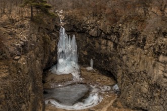 Looking down on frozen waterfall in deep crater located in Gyeonggi province of South Korea