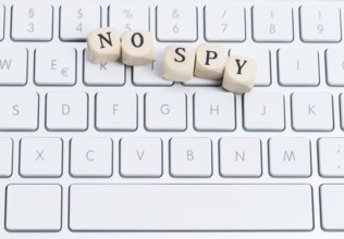 The photo shows a keyboard with wooden letters with the words