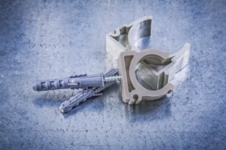 Stack of pipe clamps on metallic background construction concept
