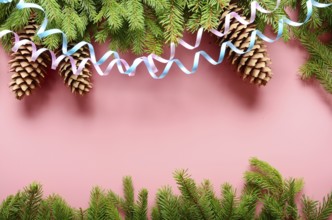 Flat lay design of Christmas greeting card of fir twigs cones and paper streamer on pink background